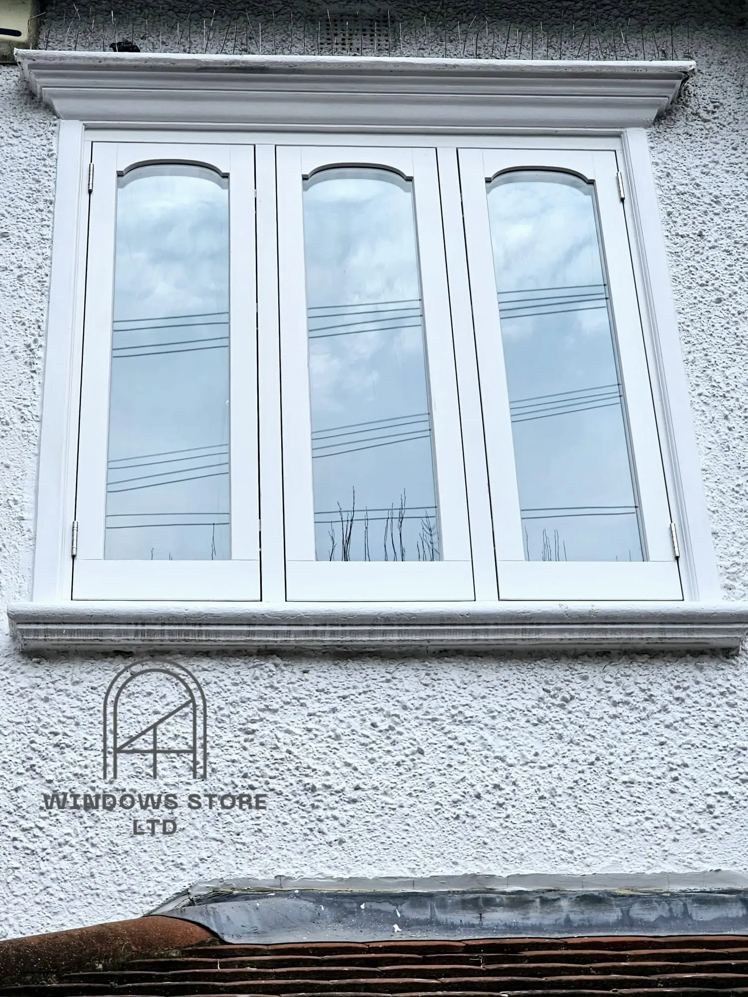 Arch-head timber casement windows on a rendered London facade