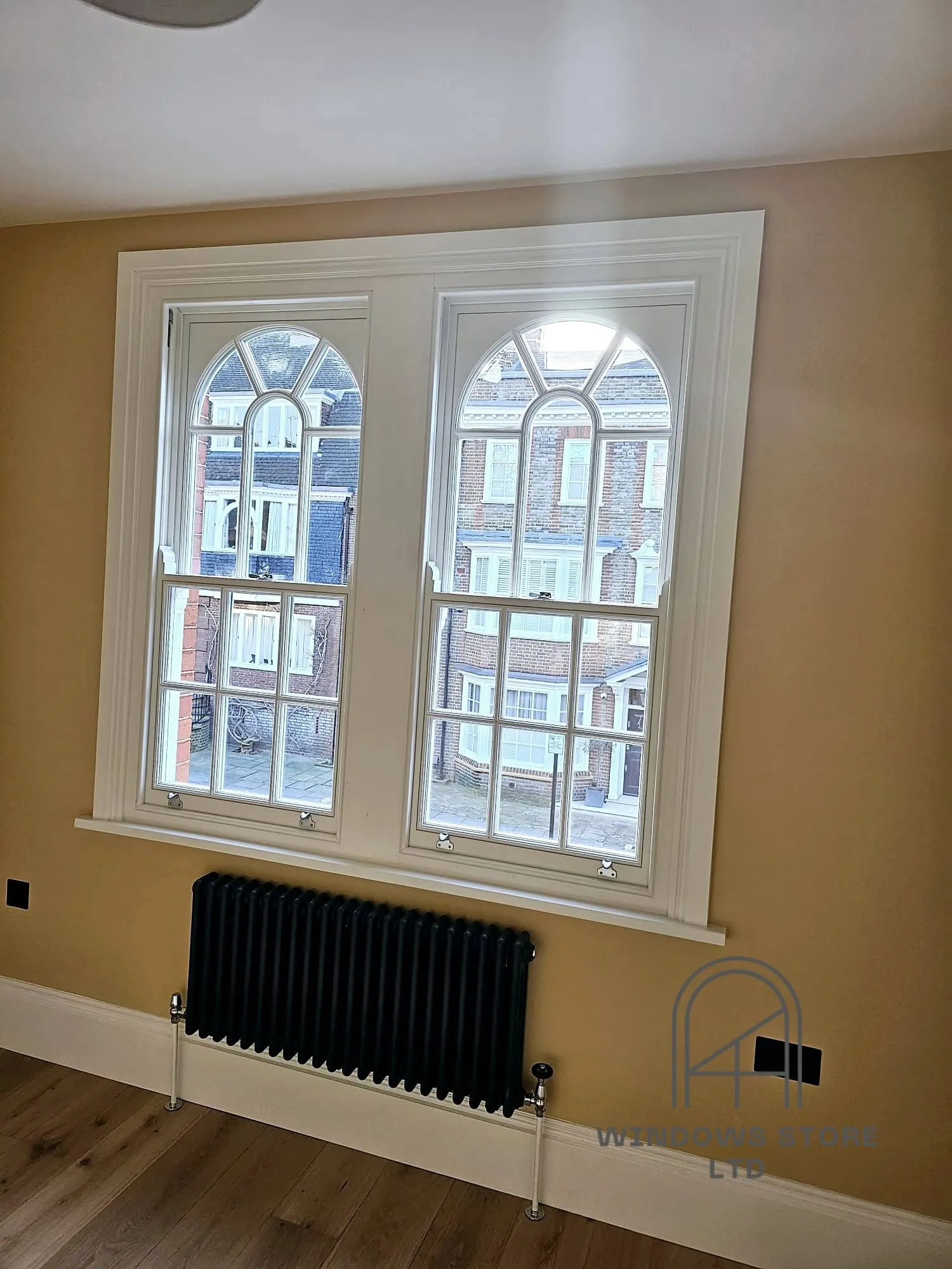 Arched-head timber sash windows in a restored London period room
