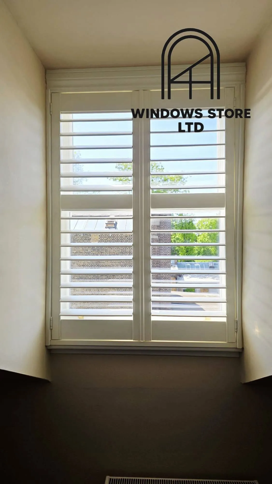 Full-height interior shutters fitted to a period window reveal, London