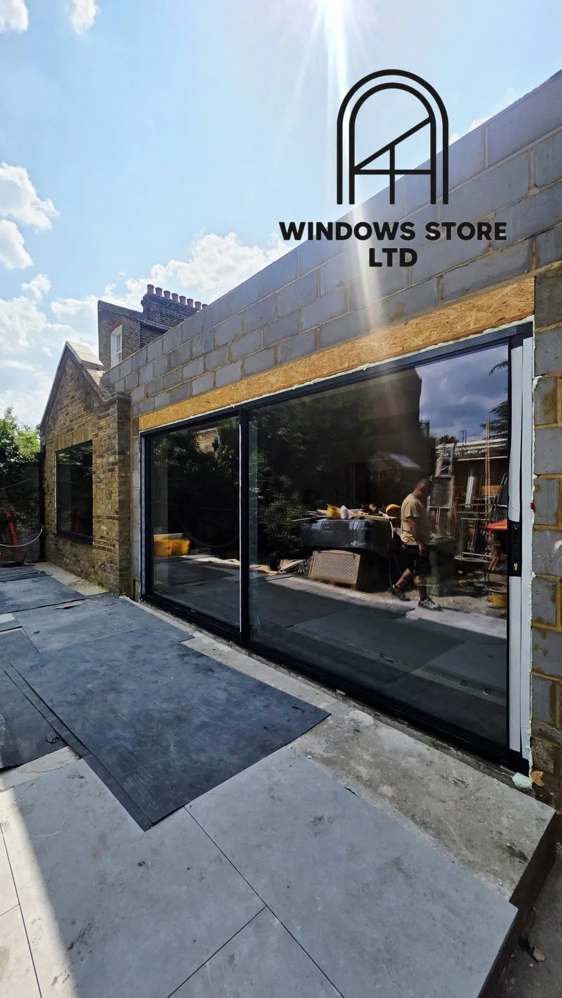 Slim-framed aluminium sliding doors with large panes onto a garden, London