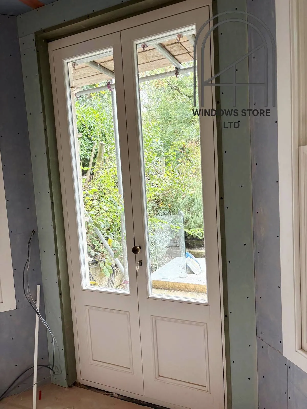 Timber double doors with glazed upper panels opening to a garden, London